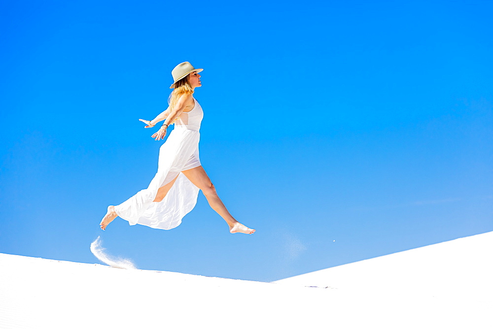 Woman jumping on the Gypsum Sand Dune, White Sands, New Mexico, United States of America, North America