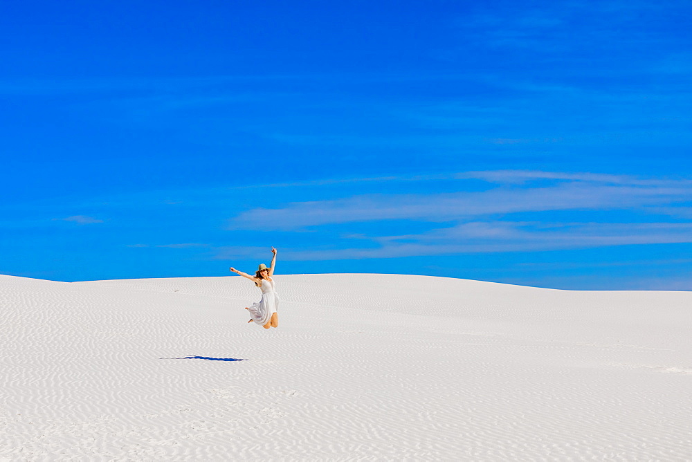 Woman jumping on Gypsum Sand Dune, White Sands, New Mexico, United States of America, North America