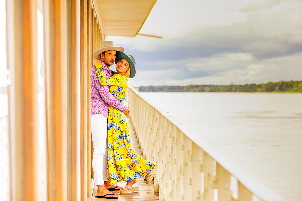 Couple posing for the camera overlooking the Amazon River aboard a river boat, Peru, South America