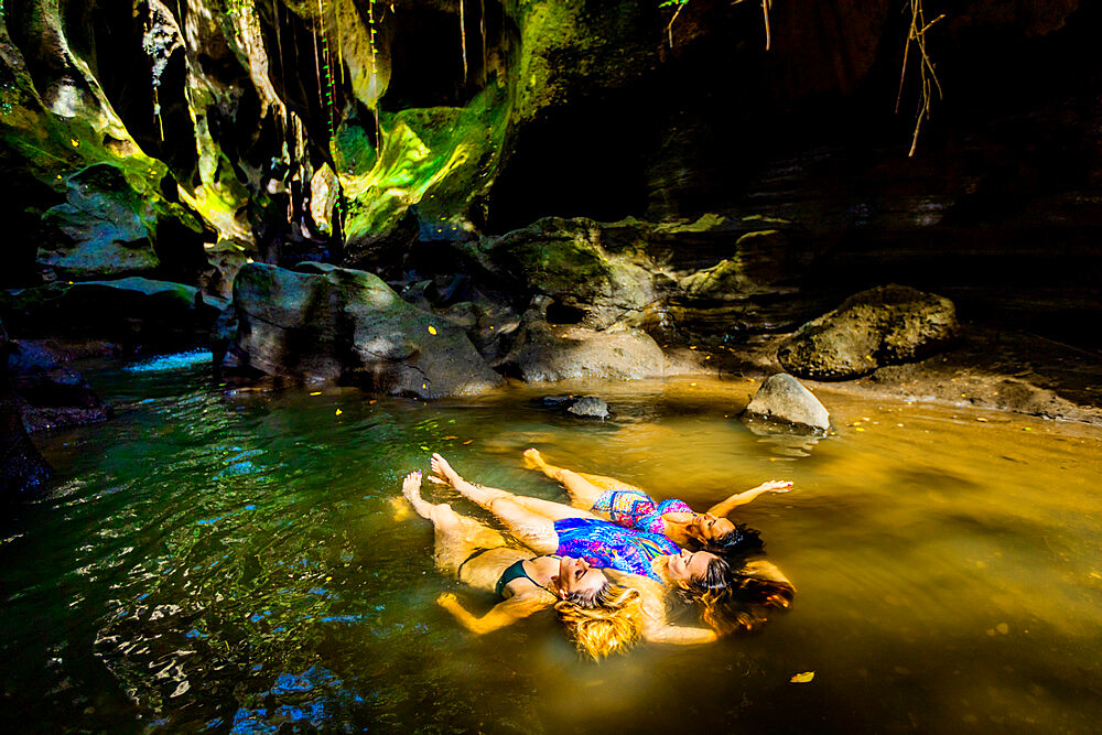 Women floating peacefully in the water at the Beji Guwang Hidden Canyon, Bali, Indonesia, Southeast Asia, Asia