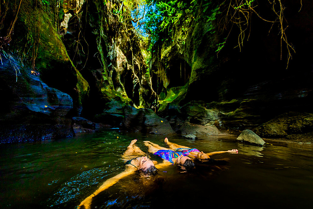 Women floating peacefully in the water at the Beji Guwang Hidden Canyon, Bali, Indonesia, Southeast Asia, Asia