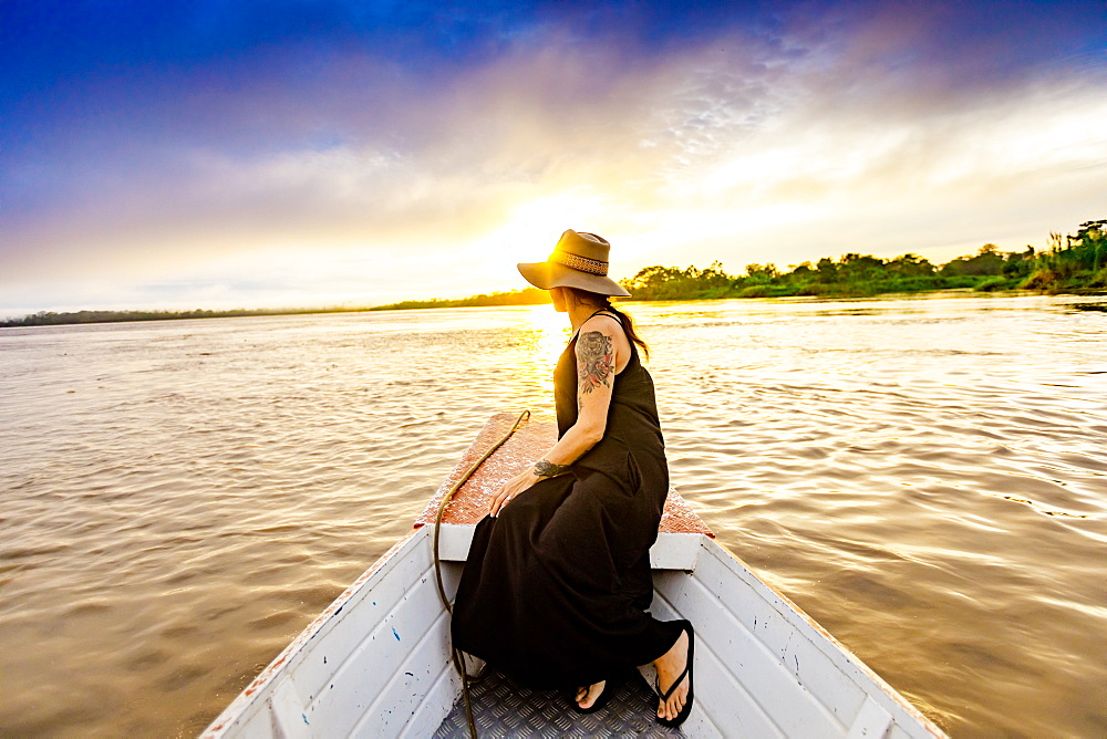 Woman enjoying sunset on the river, Amazon River, Peru, South America