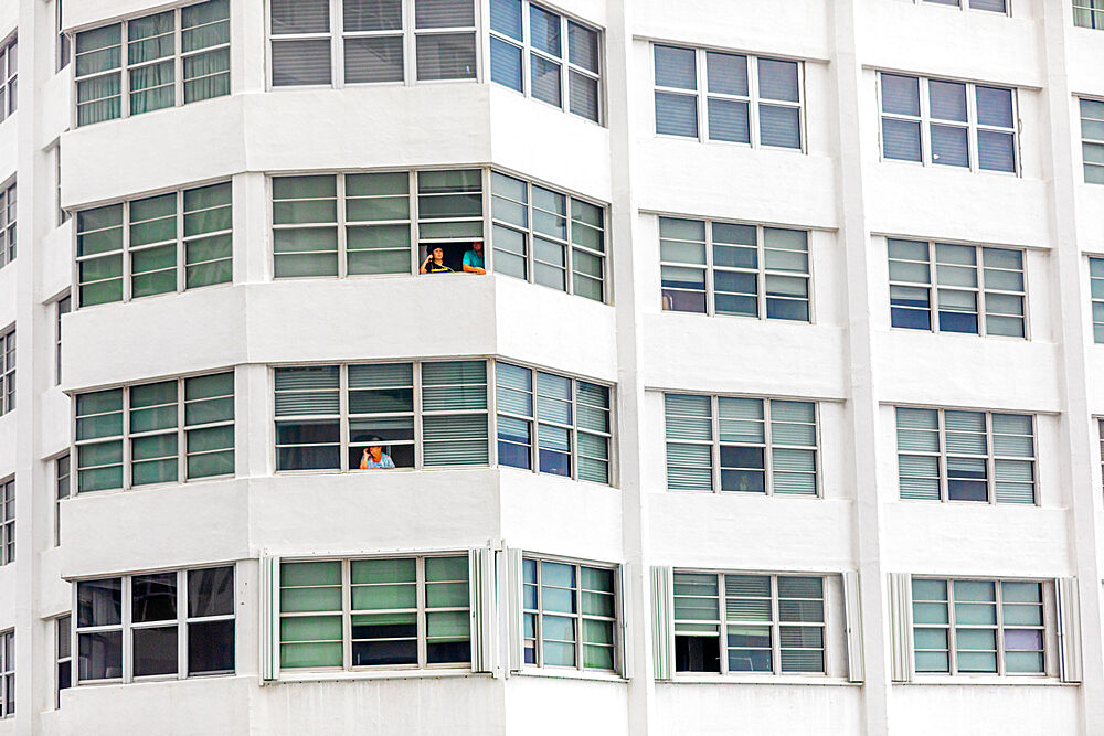 People without balconies cope with the pandemic lockdown through their windows at the Four Ambassadors Apartment Building, Miami, Florida, United States of America, North America