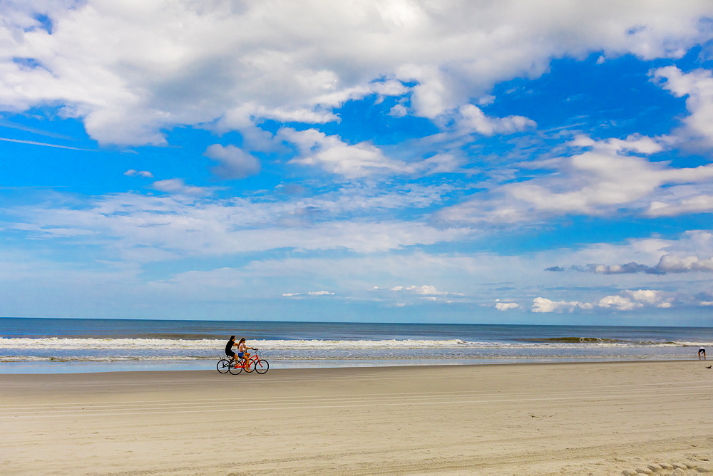 Couple bike riding on Jacksonville beach after it reopened during the Covid-19 Pandemic, Florida, United States of America, North America