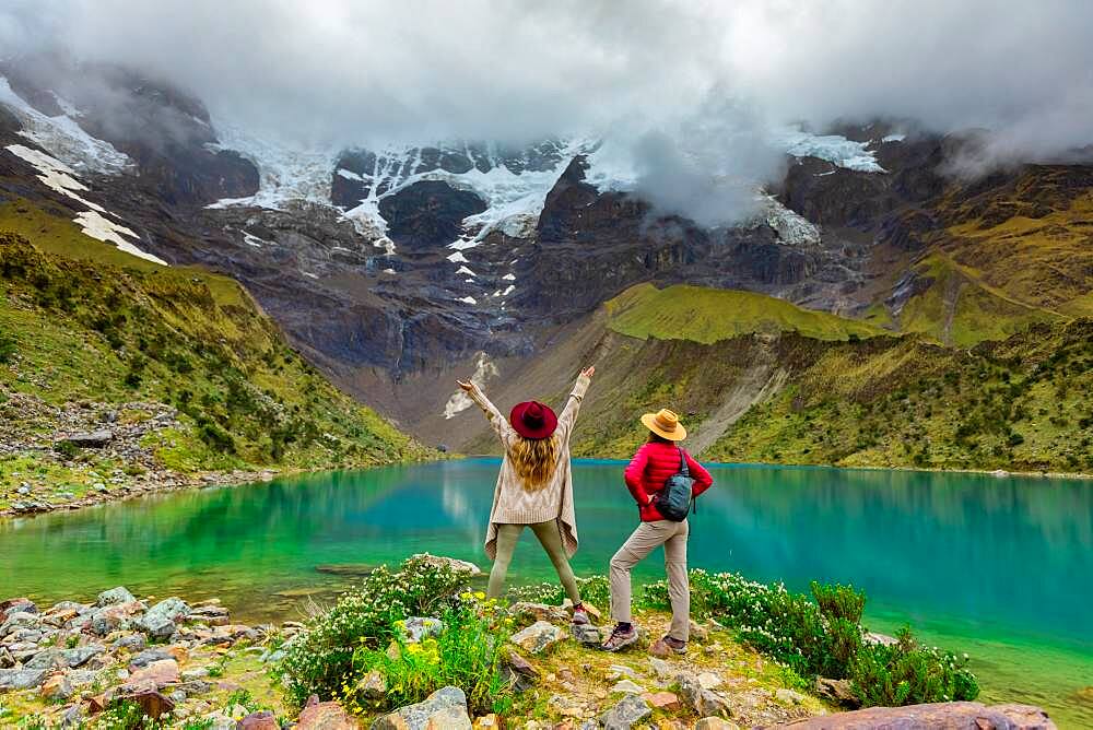 Two woman enjoying the view of crystal clear Humantay Lake, Cusco, Peru, South America