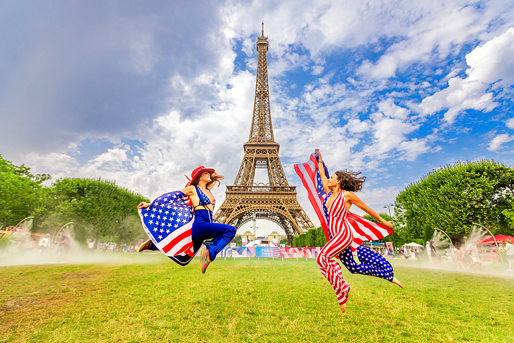 Patriotic American Woman jumping and cheering for Team USA and the Paris 2024 Olympics in front of the Eiffel Tower, Paris, France, Europe