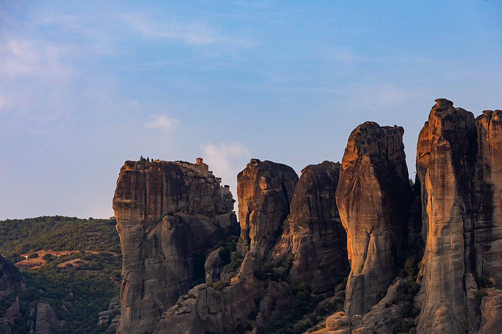 Landscape orientation view of the towering rock formations of Meteora with monasteries perched on top, seen from the town below, Thessaly, Greece.