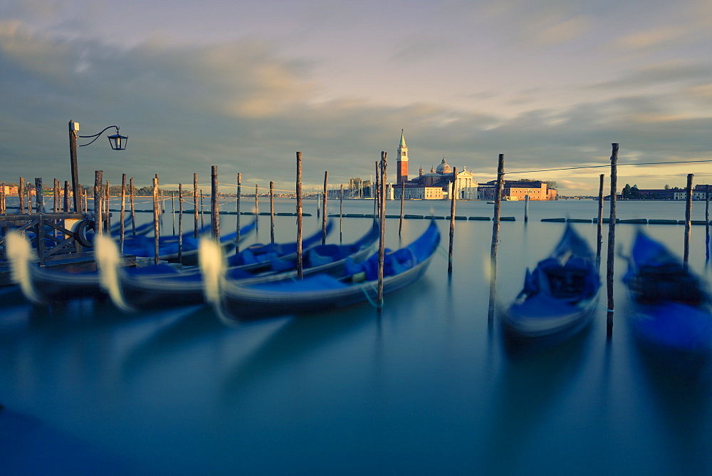 Gondolas tied to their moorings with the last light of the day illuminating San Giorgio Maggiore and its Campanile, Venice, UNESCO World Heritage Site, Veneto, Italy, Europe