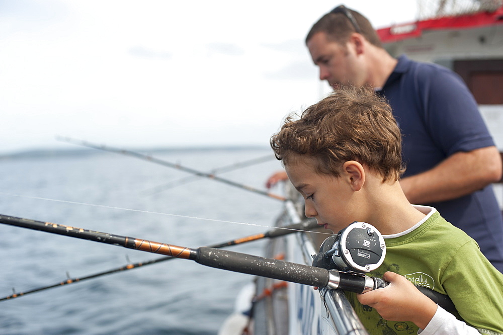 Tourists fish for mackerel on a fishing trip from Penzance, Cornwall, England, United Kingdom, Europe