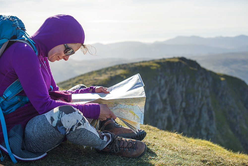 Checking a map on the way down from Helvellyn towards Grisedale Tarn in the English Lake District, Lake District National Park, Cumbria, England, United Kingdom, Europe