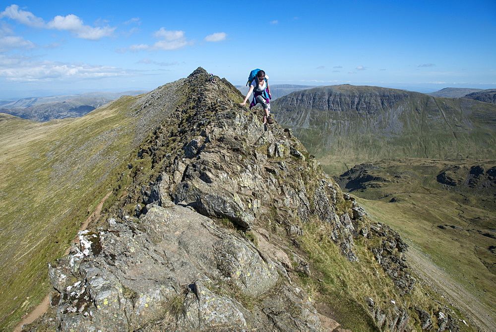 A woman on top of Striding Edge facing towards Ullswater in the English Lake District, Lake District National Park, Cumbria, England, United Kingdom, Europe