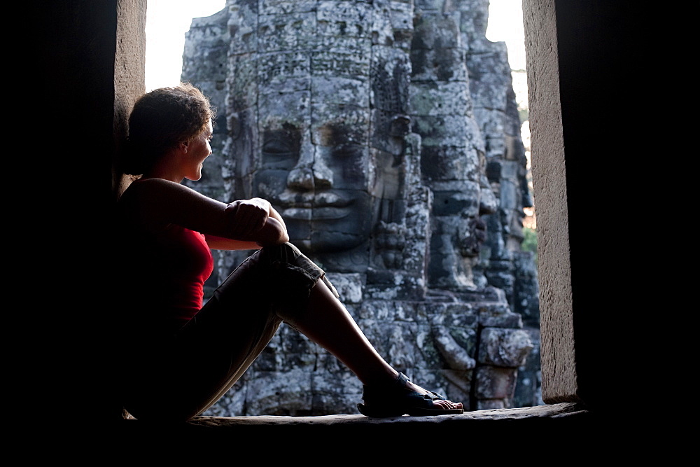 A tourist looks out from one of the doorways at the Bayon temple within Angkor, UNESCO World Heritage Site, Siem Reap, Cambodia, Indochina, Southeast Asia, Asia