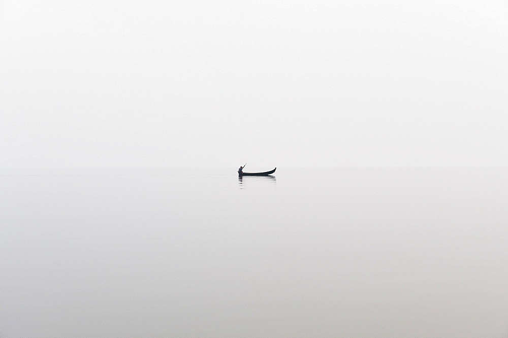 A fishing boat on a perfectly calm Indawgyi Lake in northern Myanmar on a misty afternoon, Myanmar (Burma), Asia