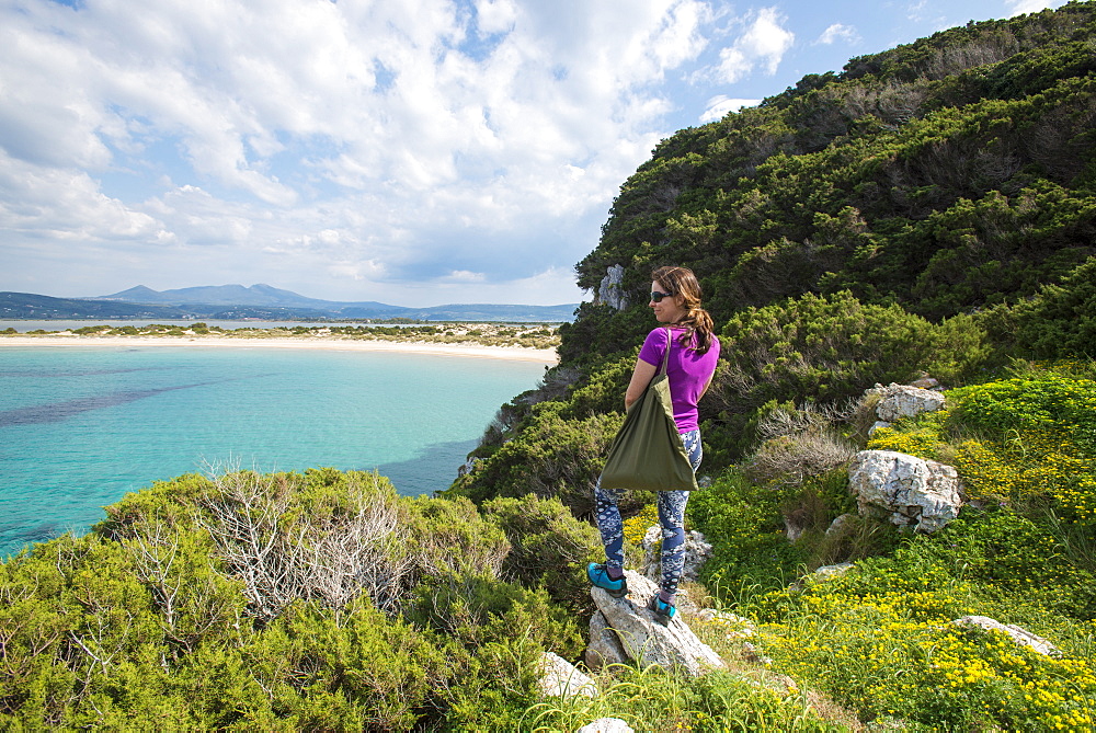 A woman explores the headland near Voidokilia Beach in the Peloponnese, Greece, Europe