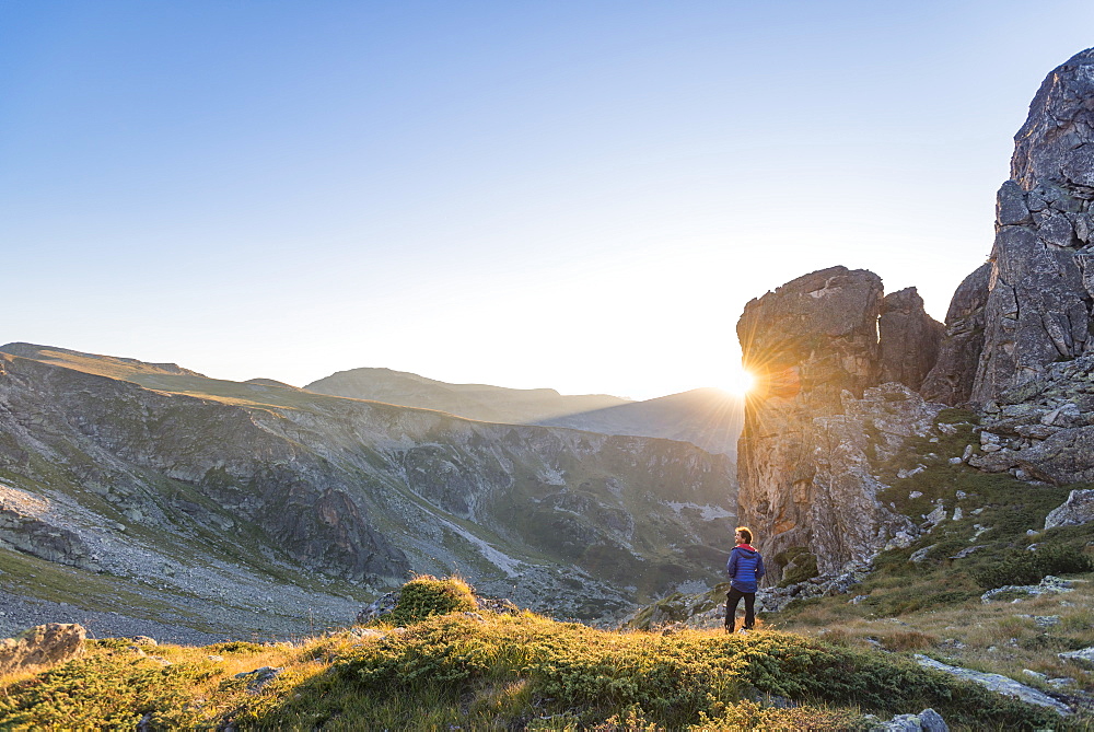 The last rays of sun disappear behind a rock face after a day of trekking in the Rila Mountains, Bulgaria, Europe