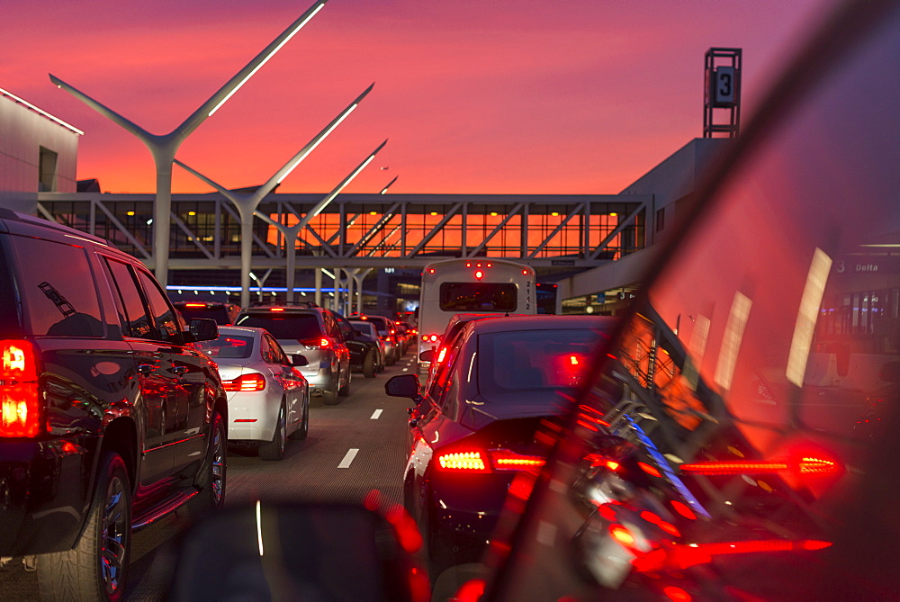 Traffic going into Los Angeles airport under a vibrant orange and pink sunset, California, United States of America, North America