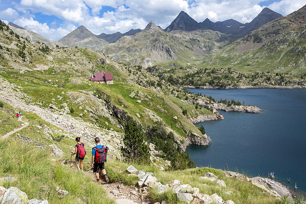 Hikers make their way along the the long distance footpath called the GR11 towards Refugio Respomuso in the Spanish Pyrenees, Huesca, Spain, Europe