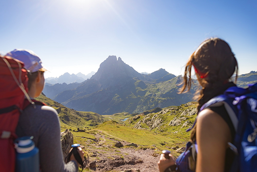 Walkers admire the view of Pic du Midi d'Ossau from the top of Col d'Ayous on the GR10 trekking route, Pyrenees Atlantiques, France, Europe