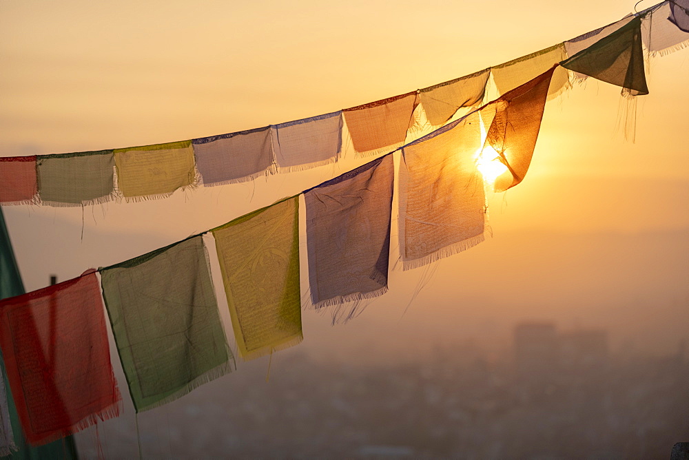 Prayer flags at Swayambhunath (Monkey Temple) in front of the city at sunrise, Kathmandu Valley, Nepal, Asia