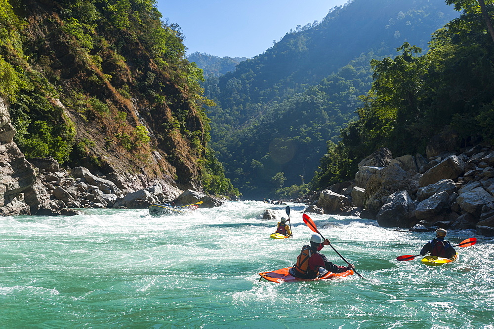 Kayakers negotiate their way through whitewater rapids on the Karnali River in west Nepal, Asia