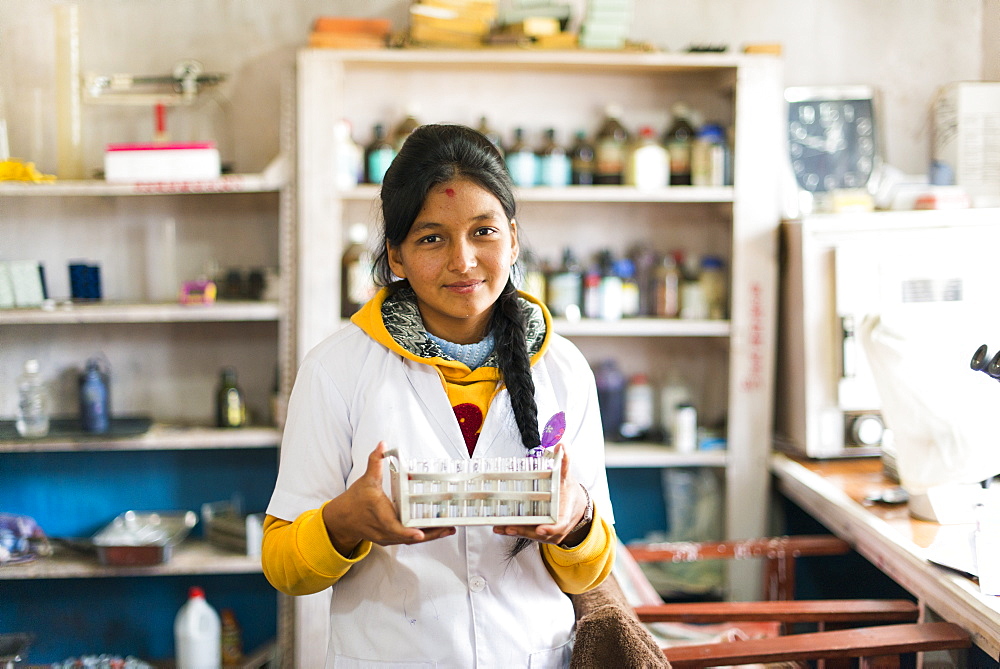 A young lab technician in a hospital in Nepal holds a rack of test tubes, Diktel, Khotang District, Nepal, Asia