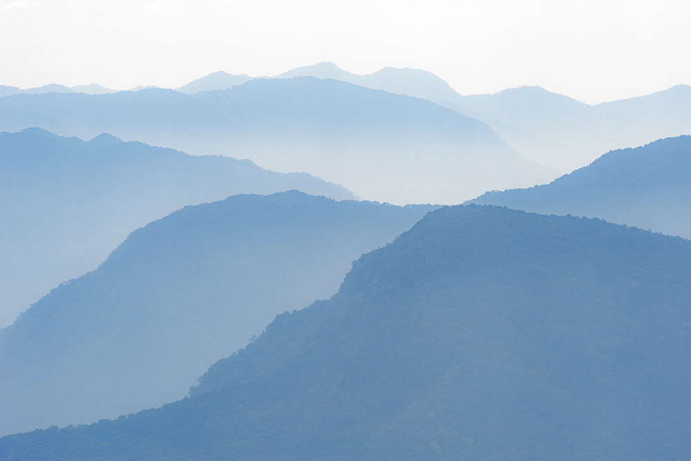 Foothills of the Himalayas in east Bhutan take on an ethereal appearance in early morning mist, Bhutan, Asia