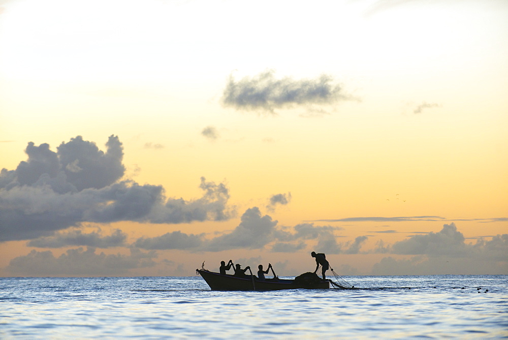 Seine fisherman lay their nets from a boat in Castara Bay in Tobago at sunset, Trinidad and Tobago, West Indies, Caribbean, Central America