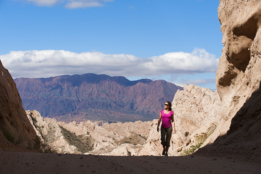 A girl walks through the stunning rock formations of the Quebrada de las Flechas, Argentina, South America