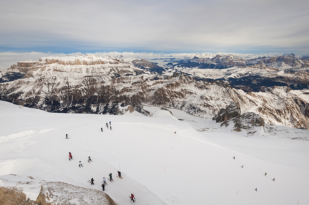 Skiers descend from the top of Marmolada in the Dolomites, Italy, Europe