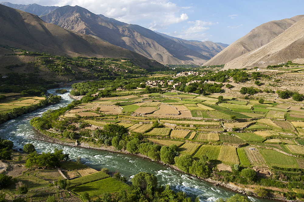 The green of the irrigated fields contrasts with the arid hills above, a testament to farmers ingenuity in this dry landscape, Afghanistan, Asia