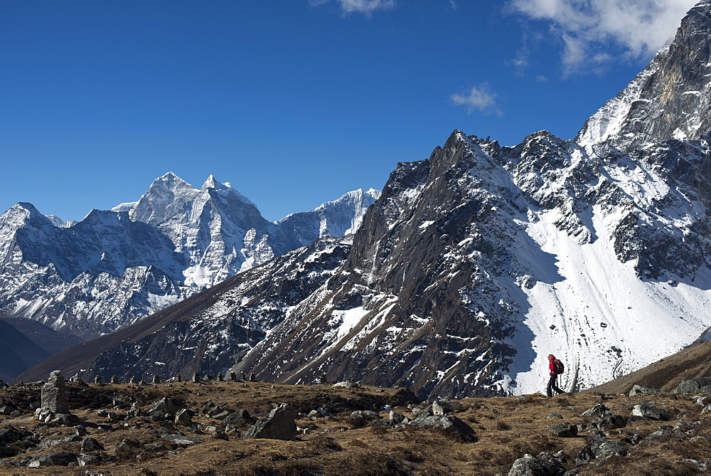 A trekker in the Everest region on the way up to Everest Base Camp seen here walking in front of Cholatse, Khumbu Region, Nepal, Himalayas, Asia