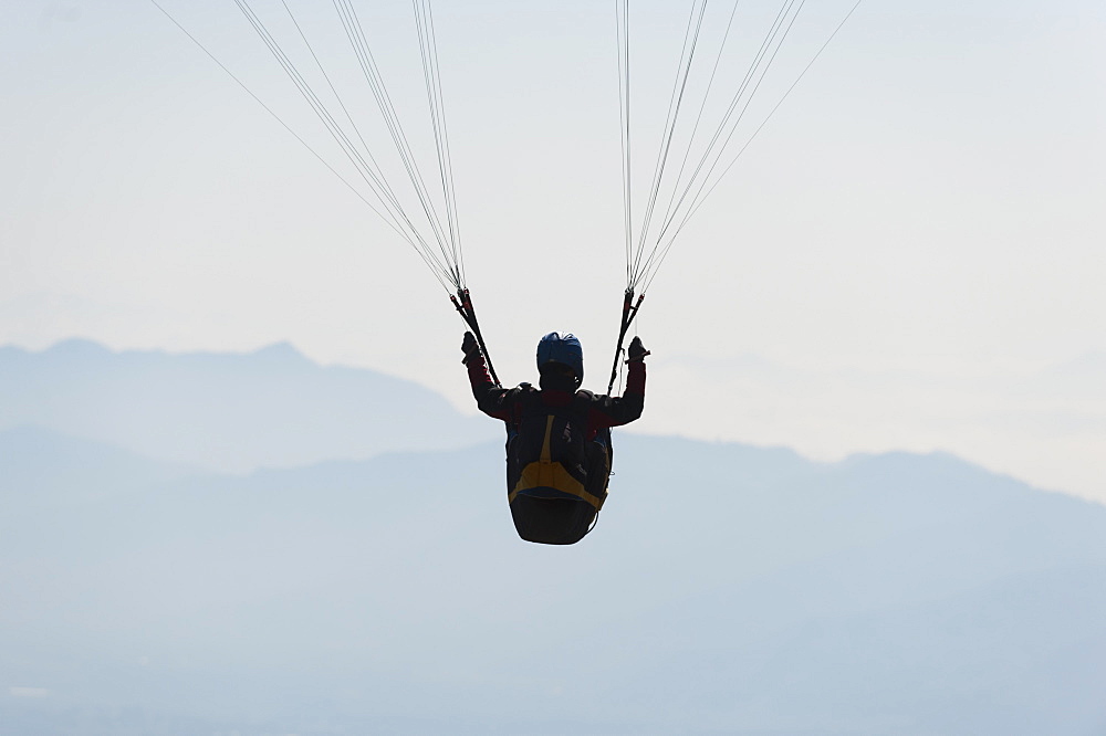 A paraglider flies above Pokhara, Nepal, Himalayas, Asia