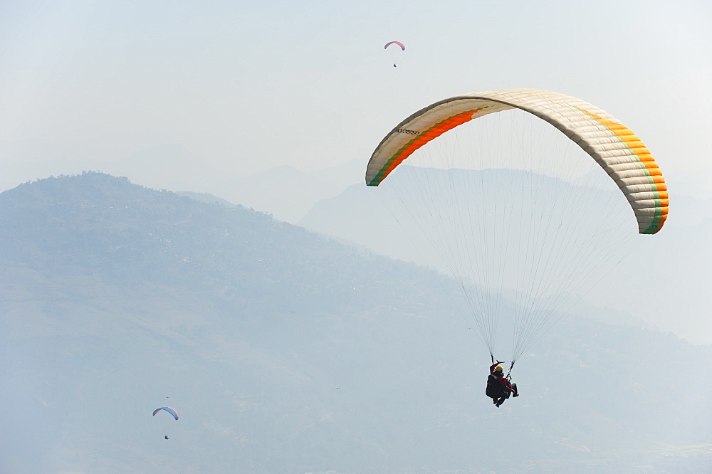 Paragliders flying above Pokhara, Nepal, Himalayas, Asia