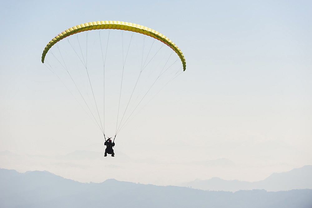 Paraglider flies above Pokhara, Nepal, Himalayas, Asia