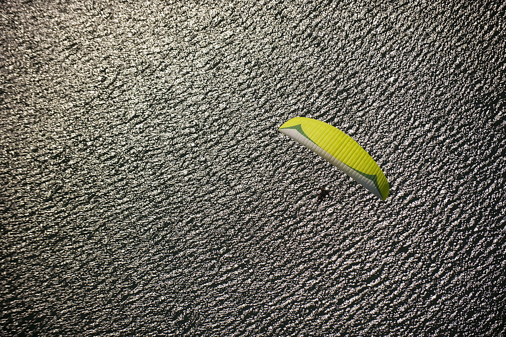 A paraglider nears the landing zone above Phewa Lake, Nepal, Asia