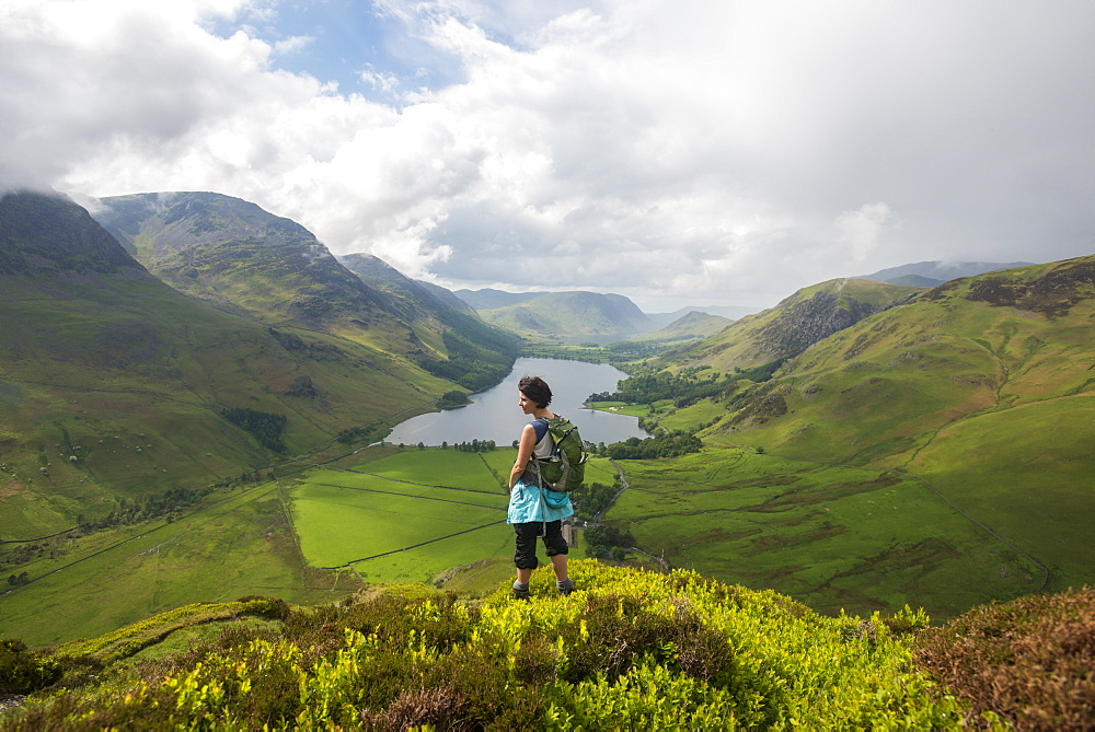 A woman looks out over Buttermere from Fleetwith Pike, Lake District National Park, Cumbria, England, United Kingdom, Europe