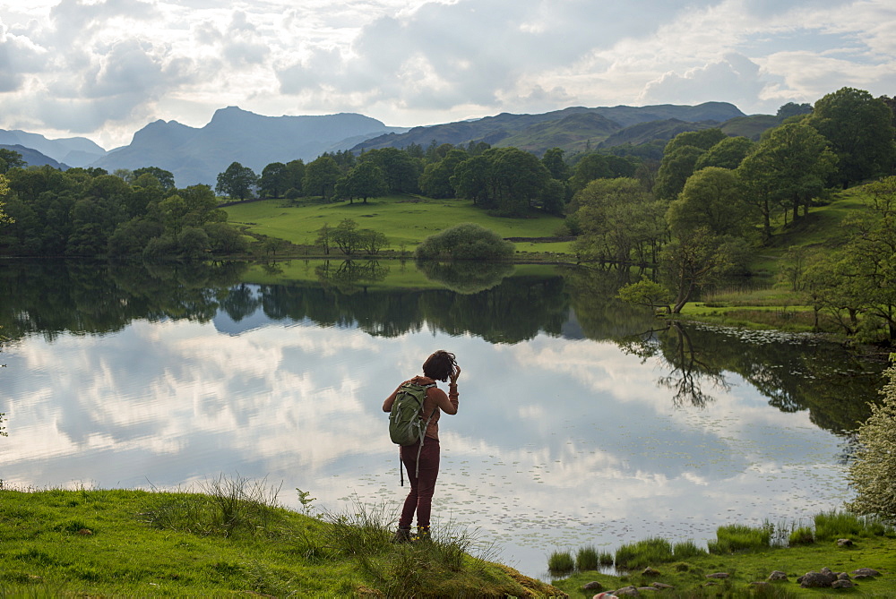 A woman looks out over Tarn Foot, Lake District National Park, Cumbria, England, United Kingdom, Europe