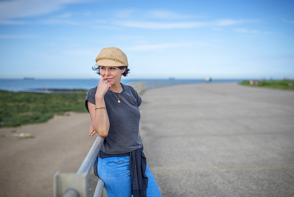 A woman looks from the sea wall at Westgate-on-Sea, Kent, England, United Kingdom, Europe