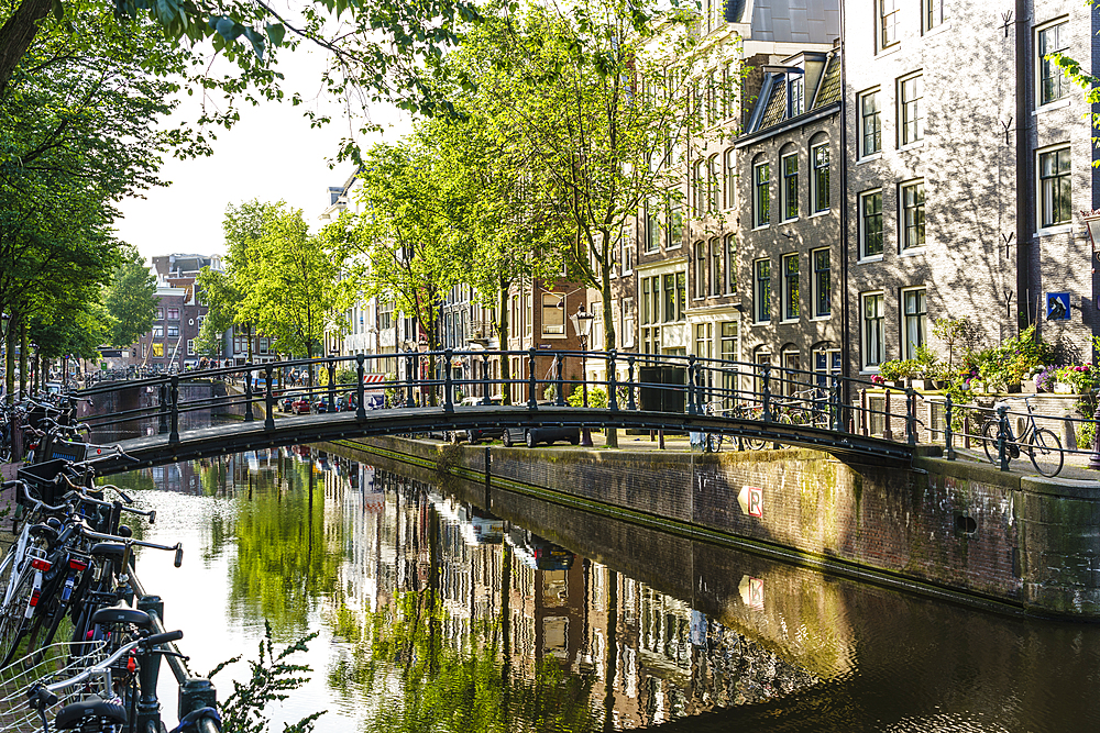 Old gabled buildings reflecting in a canal, Amsterdam, North Holland, The Netherlands, Europe