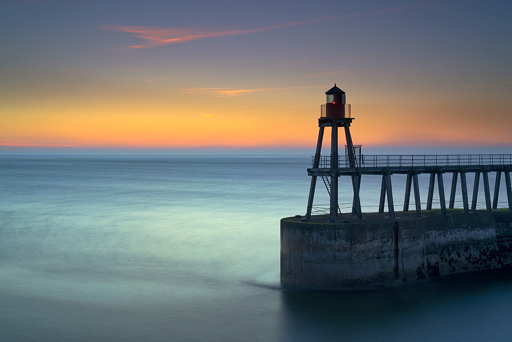 Daybreak over Whitby East Pier and lighthouse, North Yorkshire, England, United Kingdom, Europe