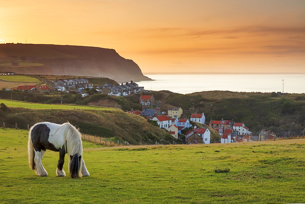 Staithes fishing village and distant Boulby Cliffs on the North Yorkshire Heritage Coastline, Staithes, Yorkshire, England, United Kingdom, Europe