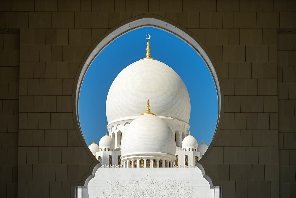 A mosque is framed by an arched passageway in Abu Dhabi, United Arab Emirates, Middle East