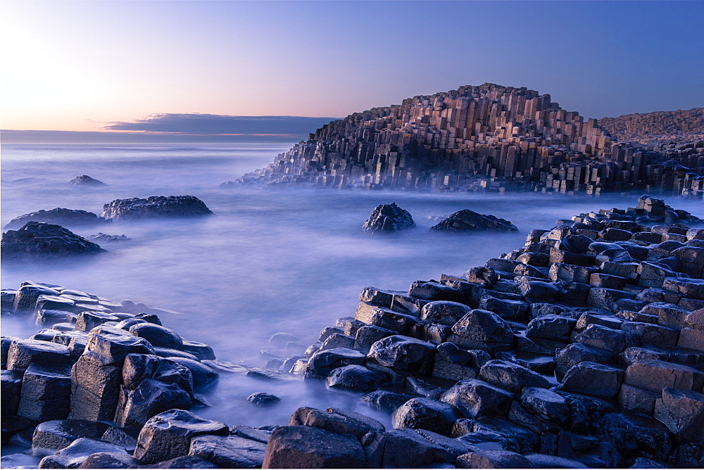 The Giant's Causeway rises out of the Atlantic late at night as the last light of the sun disappears below the horizon, County Antrim, Northern Ireland, United Kingdom, Europe