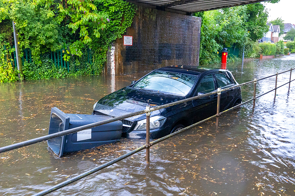 Flooded street with floating bin stuck in front of car, Sutton Coldfield, England, United Kingdom, Europe