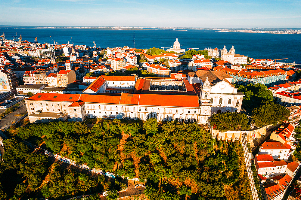 Aerial drone view of Miradouro da Graca with National Pantheon visible and large cruise ship moored on the Tagus River harbour, Lisbon, Portugal, Europe