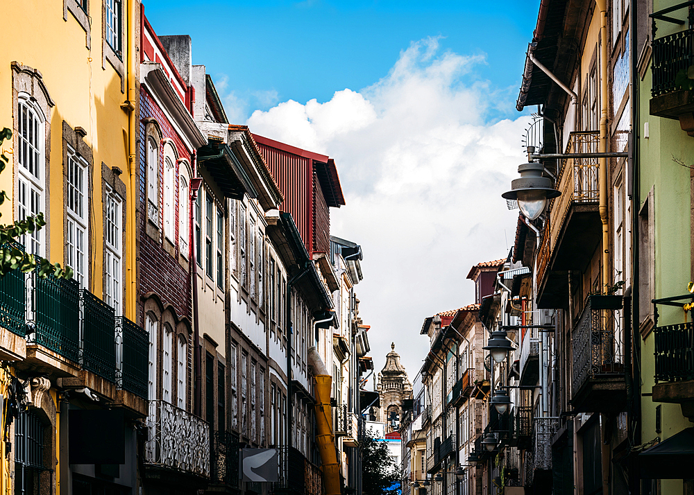 Narrow pedestrian street in the historic city centre with the Cathedral tower in the background, Braga, Minho, Portugal, Europe