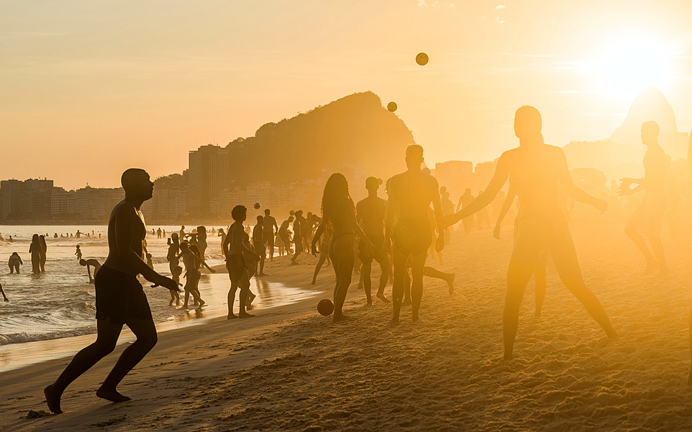 People relaxing and playing keepy-uppy at sunset, Copacabana Beach, Rio de Janeiro, Brazil, South America