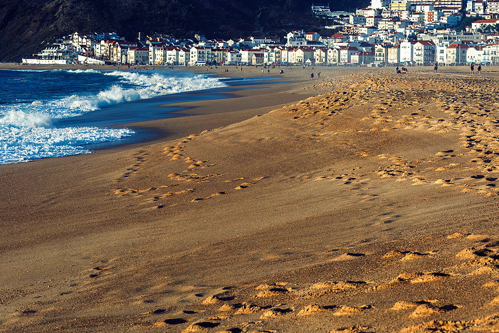 Selective focus view of the beach wtih fishing town of Nazare in the background, known for the largest waves in the world