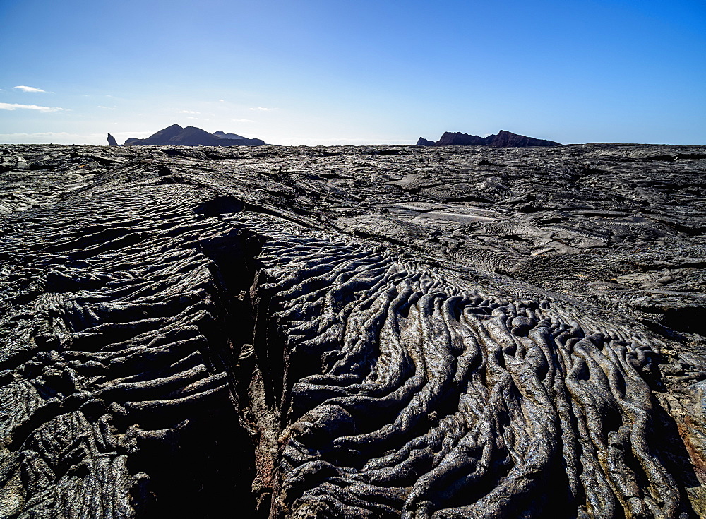 View over Lava field in Sullivan Bay towards Bartolome Island, Santiago (James) Island, Galapagos, UNESCO World Heritage Site, Ecuador, South America