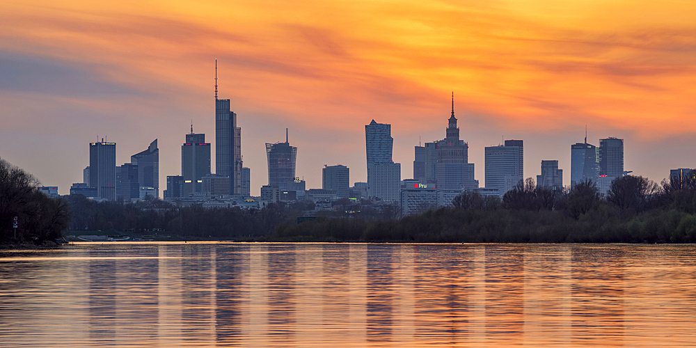 View over River Vistula towards City Centre Skyline at sunset, Warsaw, Masovian Voivodeship, Poland, Europe